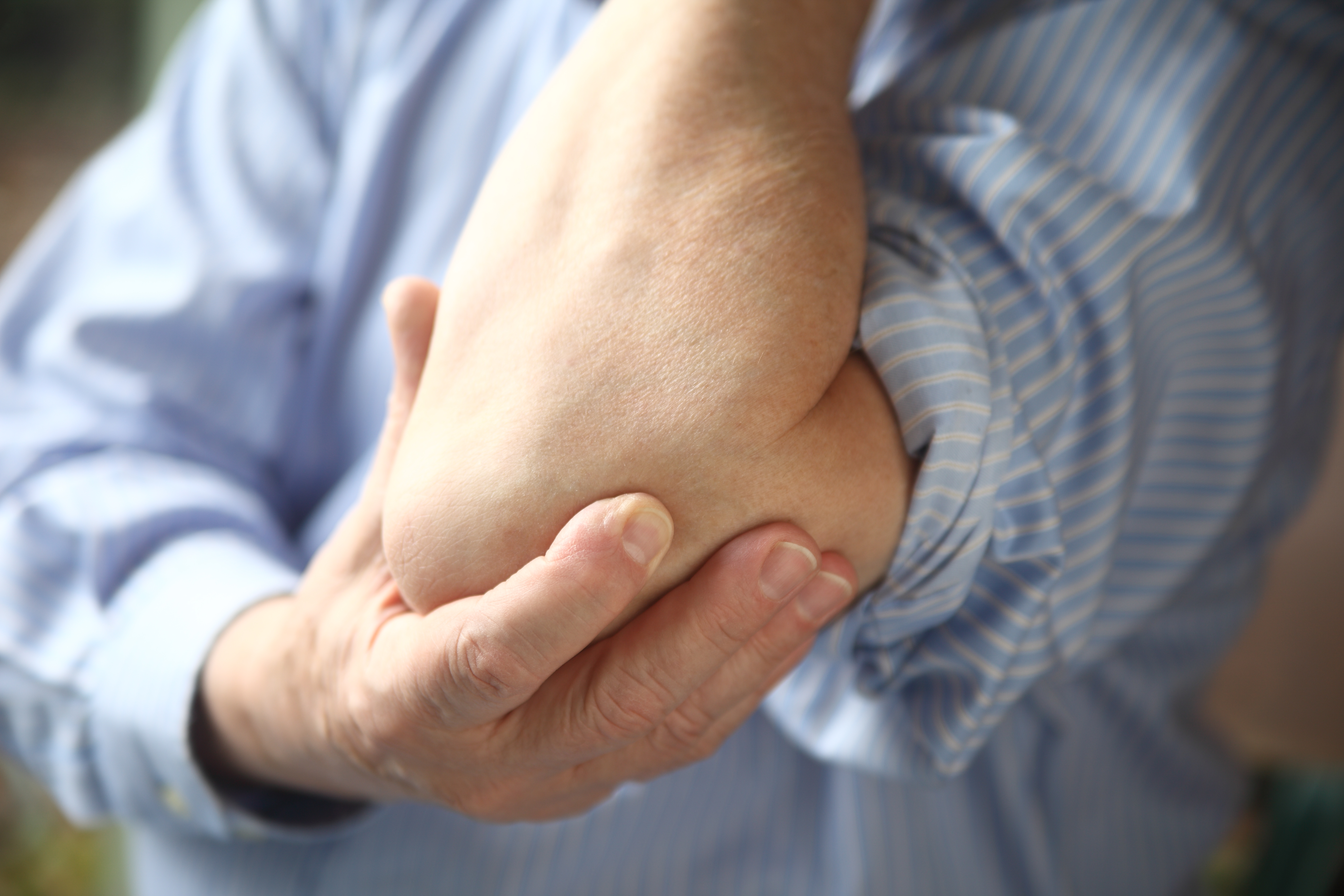 Man holding painful elbow Tendonitis
